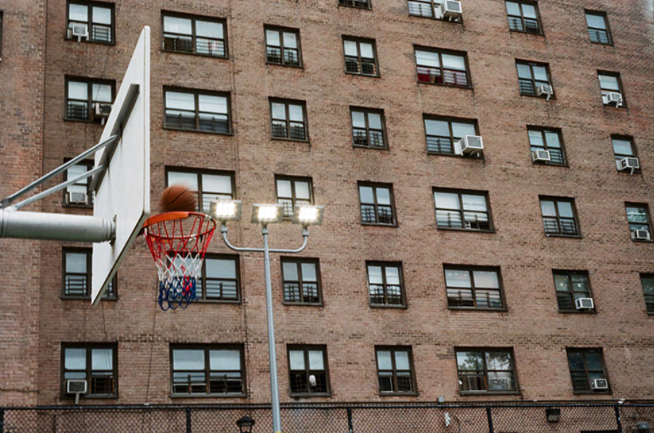 Basketball with red white blue net at Bushwick Houses basketball courts in Brooklyn, NY.
